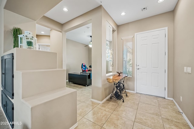 tiled foyer with ceiling fan