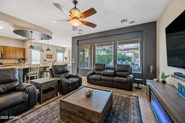 living room featuring ceiling fan, a healthy amount of sunlight, and light tile patterned floors