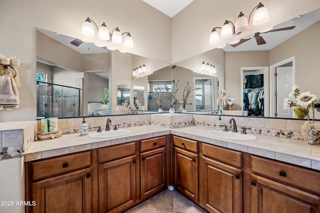 bathroom with tasteful backsplash, tile patterned flooring, vanity, an enclosed shower, and ceiling fan