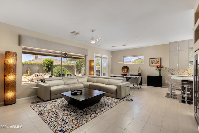 living area featuring visible vents, ceiling fan, baseboards, and light tile patterned floors