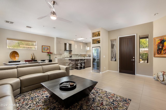 living room with a ceiling fan, visible vents, baseboards, and light tile patterned floors