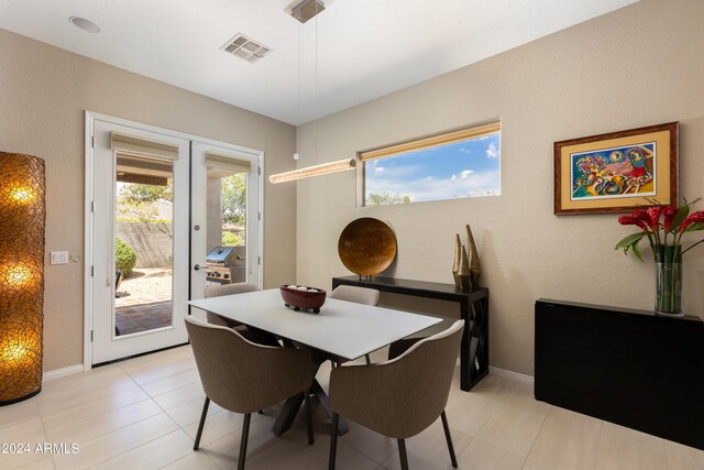 tiled dining space featuring french doors