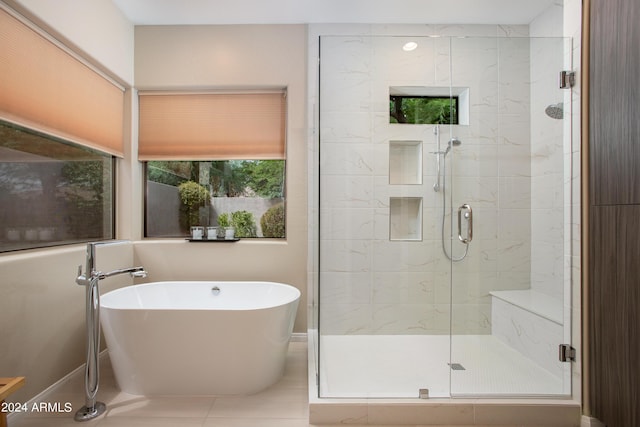 bathroom featuring a stall shower, a freestanding tub, and tile patterned floors