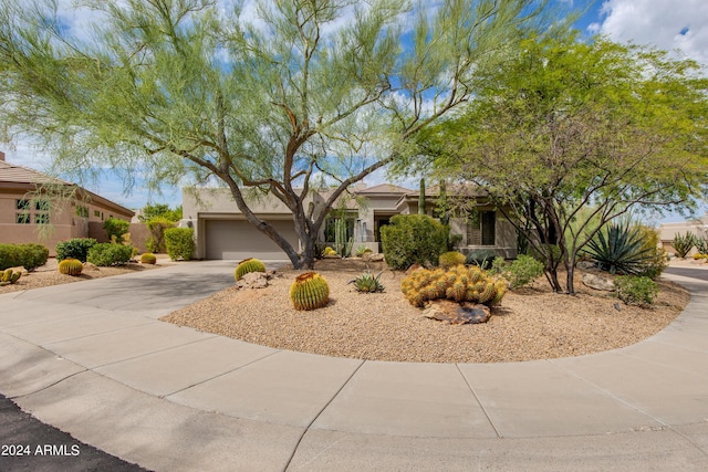 view of front of home with a garage, driveway, and stucco siding