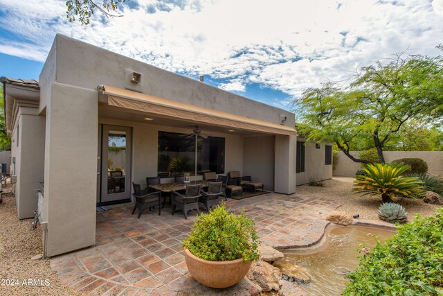 rear view of house featuring ceiling fan and a patio