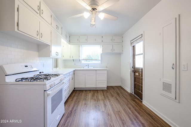 kitchen featuring sink, backsplash, gas range gas stove, white cabinets, and hardwood / wood-style flooring