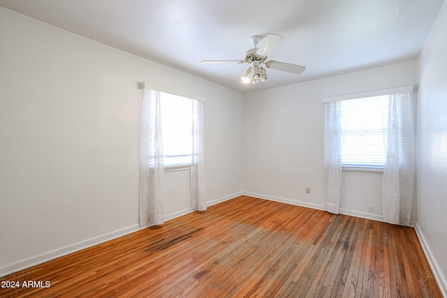 empty room with hardwood / wood-style flooring and ceiling fan