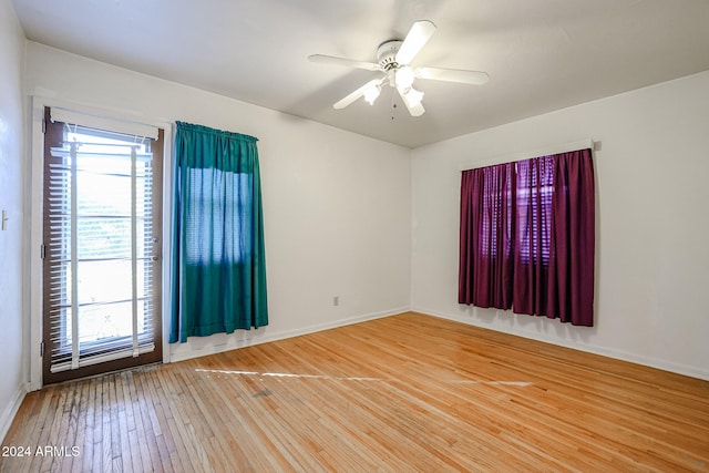 empty room with hardwood / wood-style floors and ceiling fan