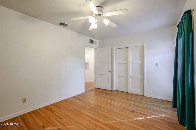 unfurnished bedroom with a closet, light hardwood / wood-style floors, and ceiling fan