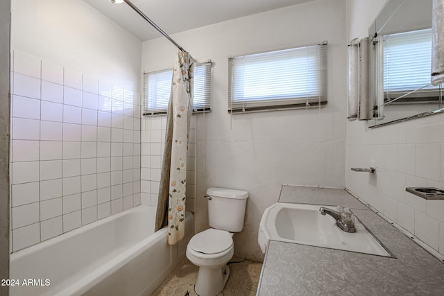 full bathroom with toilet, a healthy amount of sunlight, shower / bath combination with curtain, and vanity