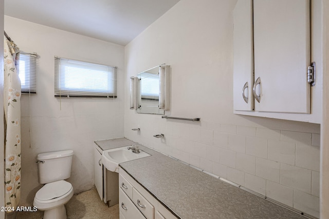 bathroom featuring tile walls, vanity, and toilet