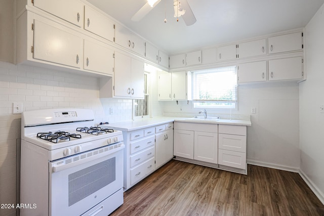 kitchen featuring dark wood-type flooring, gas range gas stove, sink, white cabinetry, and tasteful backsplash