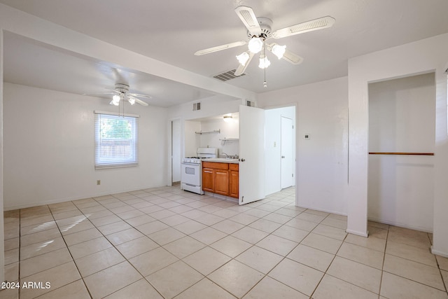 kitchen featuring ceiling fan, white gas range oven, and light tile patterned floors