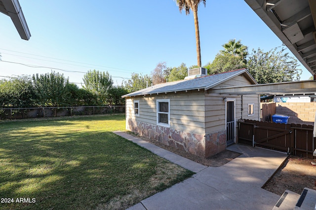 view of side of home with an outbuilding and a lawn