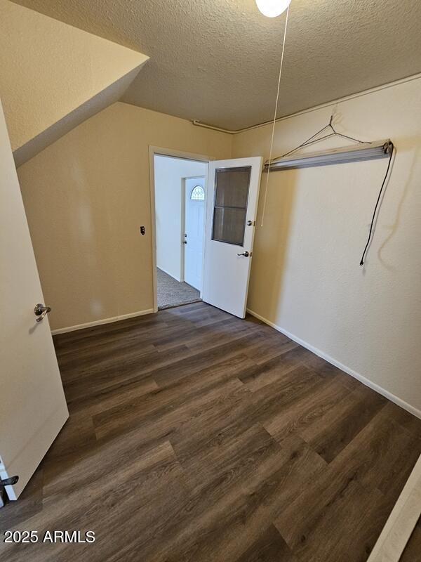 foyer with a textured ceiling, baseboards, and wood finished floors