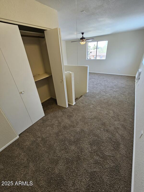 unfurnished bedroom with a closet, dark colored carpet, and a textured ceiling