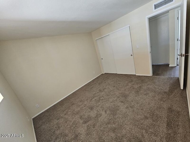 unfurnished bedroom featuring carpet floors, baseboards, visible vents, and a closet