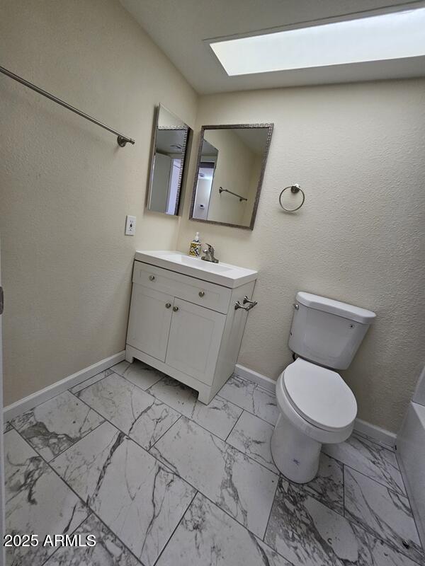 bathroom with marble finish floor and baseboards