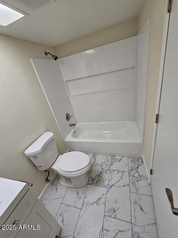 full bathroom featuring toilet, shower / bath combination, visible vents, vanity, and marble finish floor