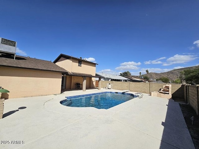 view of swimming pool featuring a patio area, a fenced backyard, a mountain view, and a fenced in pool