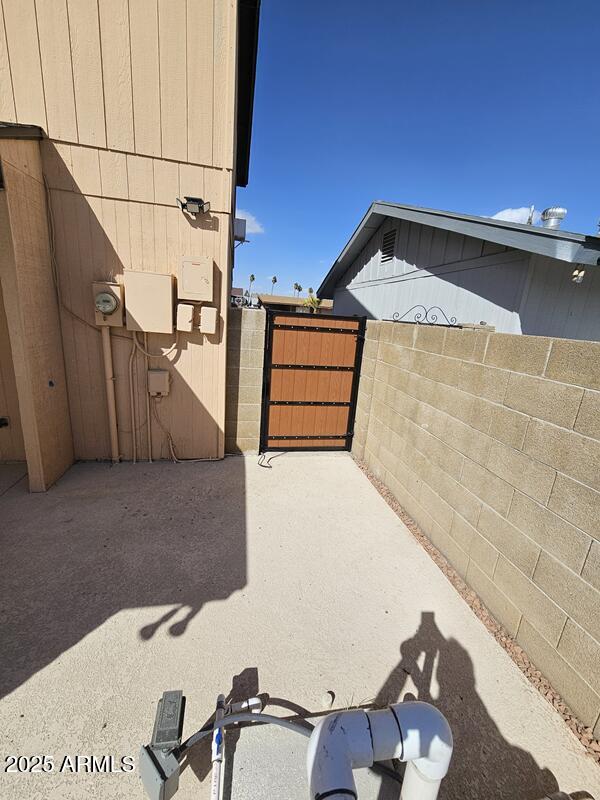 view of patio with fence and a gate