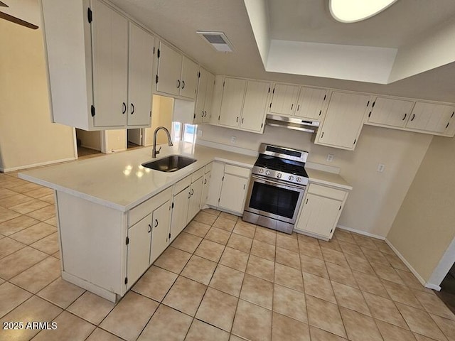 kitchen with under cabinet range hood, a sink, baseboards, light countertops, and stainless steel range with gas stovetop