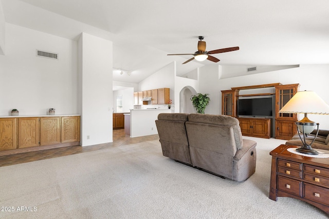 living area with ceiling fan, light colored carpet, and high vaulted ceiling