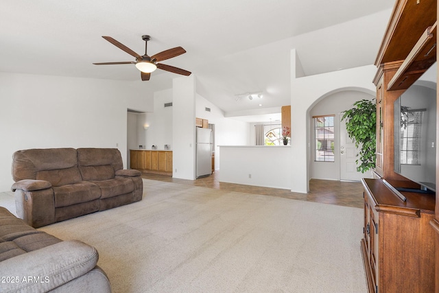 living area with a ceiling fan, light colored carpet, and high vaulted ceiling