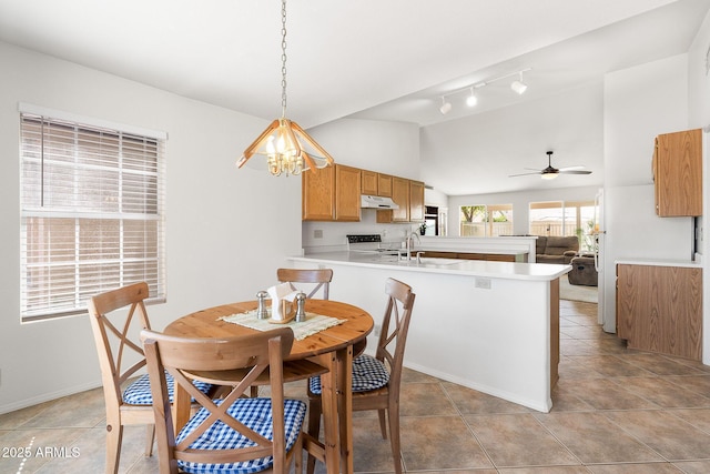 dining room featuring vaulted ceiling, ceiling fan, track lighting, light tile patterned floors, and a chandelier