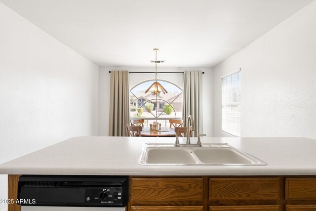 kitchen featuring dishwasher, a chandelier, a sink, light countertops, and decorative light fixtures