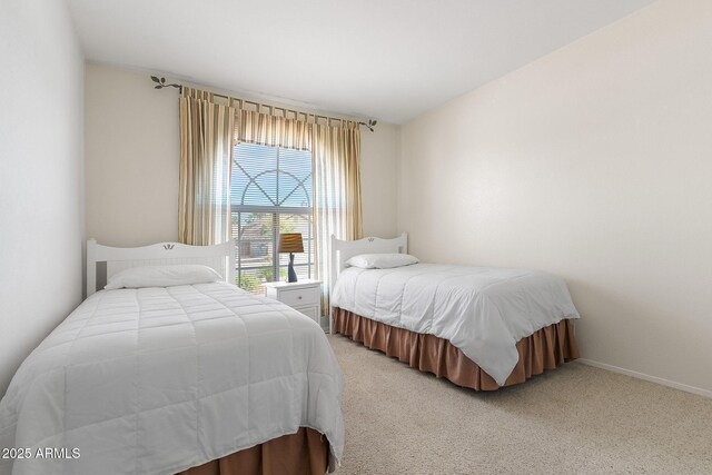 bedroom with light colored carpet and baseboards