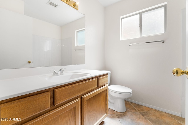 bathroom with toilet, vanity, tile patterned floors, and baseboards