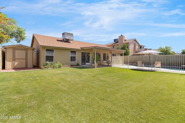 rear view of property featuring a storage shed, a patio, central AC, an outdoor structure, and stucco siding