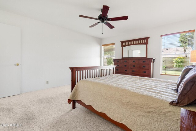 carpeted bedroom with multiple windows and ceiling fan