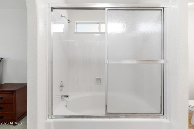 full bath with bath / shower combo with glass door and toilet