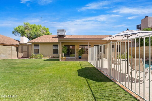 rear view of house with a shed, an outdoor structure, a patio, central AC unit, and stucco siding