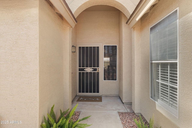 entrance to property featuring stucco siding