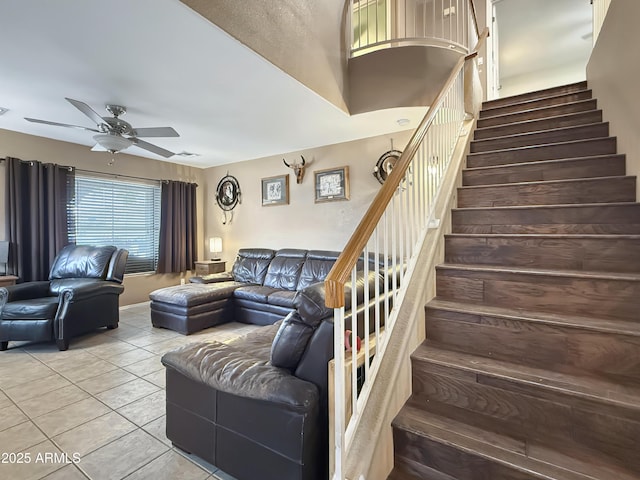 stairway featuring tile patterned floors and ceiling fan