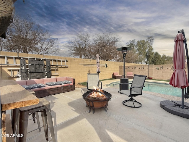 view of patio with an outdoor living space with a fire pit and a fenced in pool