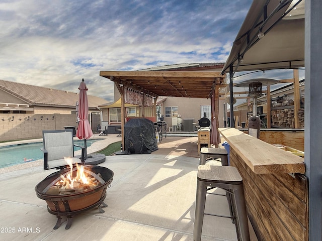 view of patio featuring exterior bar and an outdoor fire pit