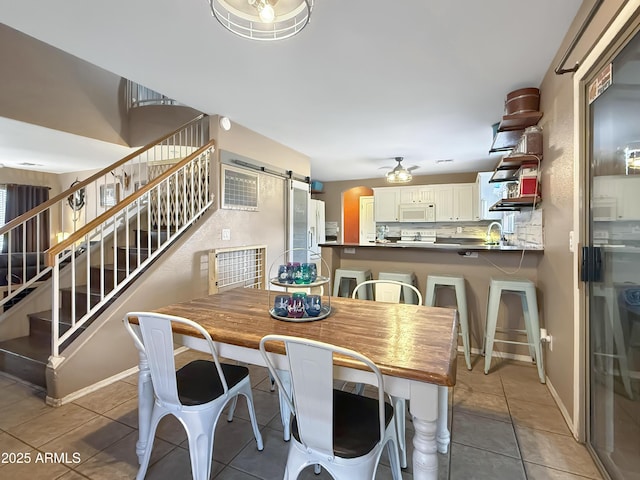 tiled dining space with sink and a barn door