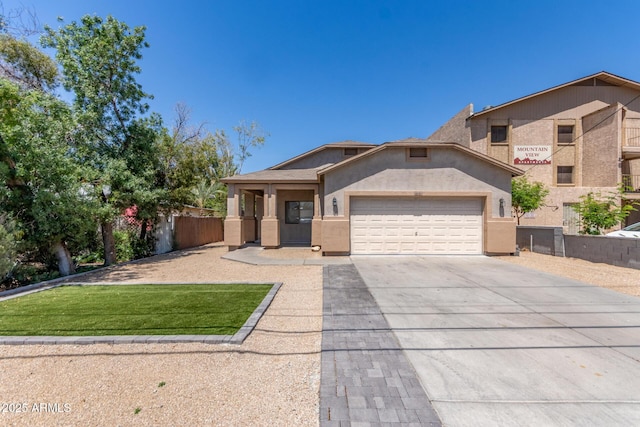 520 E Townley Ave, Phoenix, AZ 85020 - view of front facade featuring a garage, concrete driveway, fence, and stucco siding