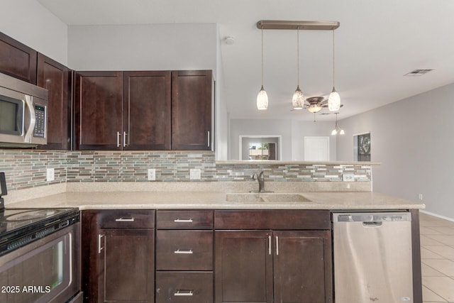 520 E Townley Ave, Phoenix, AZ 85020 - kitchen with light tile patterned floors, a sink, a peninsula, tasteful backsplash, and appliances with stainless steel finishes
