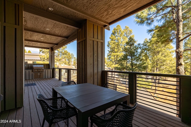 wooden terrace featuring area for grilling and exterior kitchen