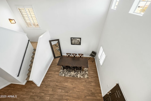 staircase featuring hardwood / wood-style floors and a towering ceiling