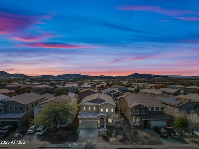 aerial view at dusk featuring a mountain view