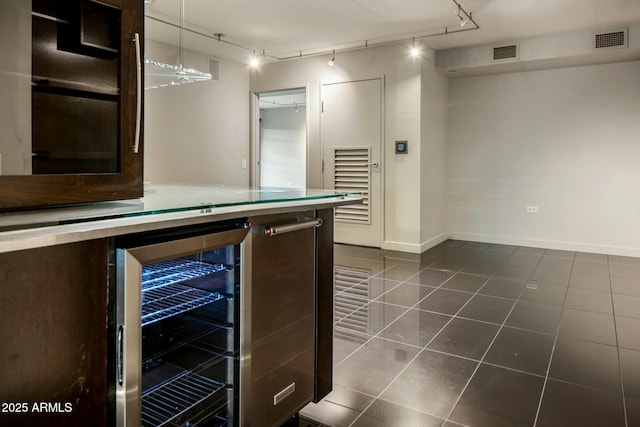 bar featuring dark tile patterned floors, beverage cooler, hanging light fixtures, and rail lighting