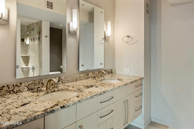 bathroom with vanity and tiled shower