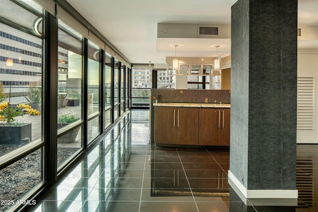 hallway with dark tile patterned flooring and expansive windows