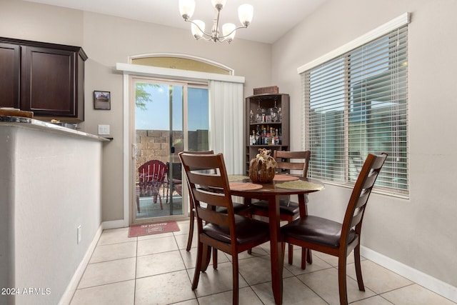 dining area featuring light tile patterned floors and a notable chandelier